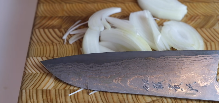 Knife blade together with chopped onion