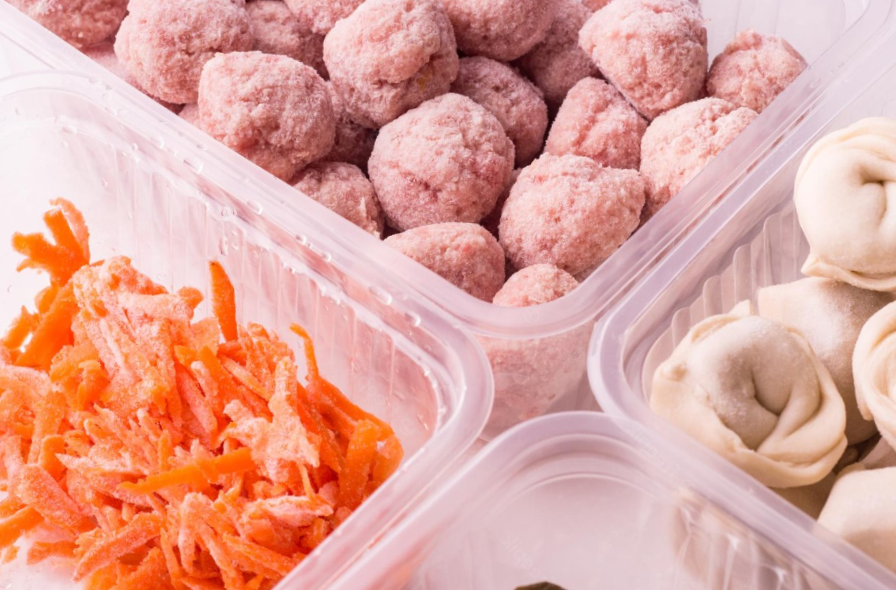 frozen meatballs, dumplings and shredded carrot in plastic containers